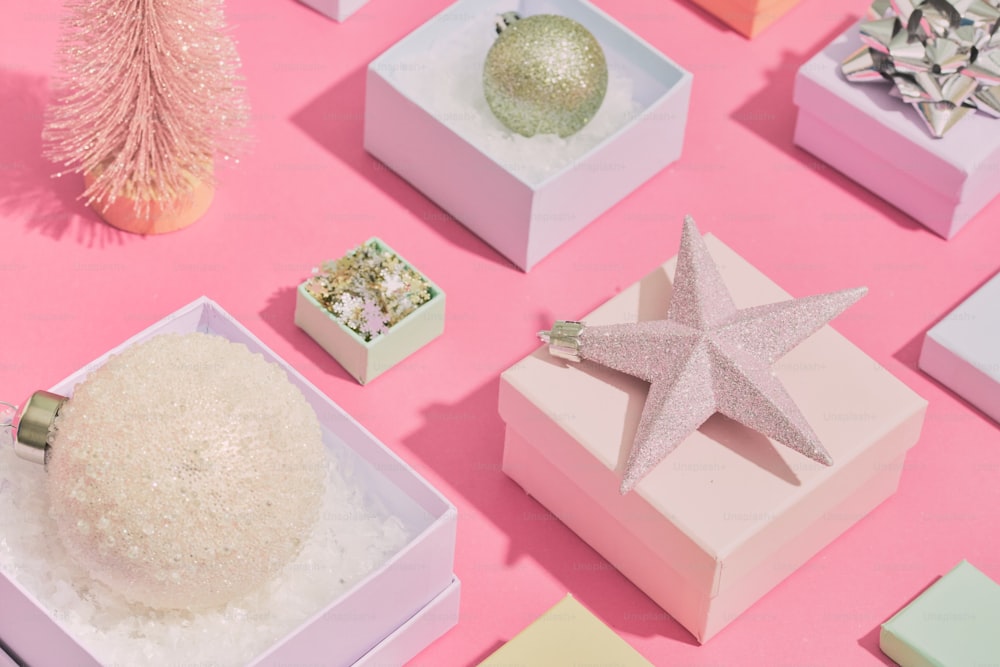 uma mesa rosa coberta com caixas e um ornamento de estrela