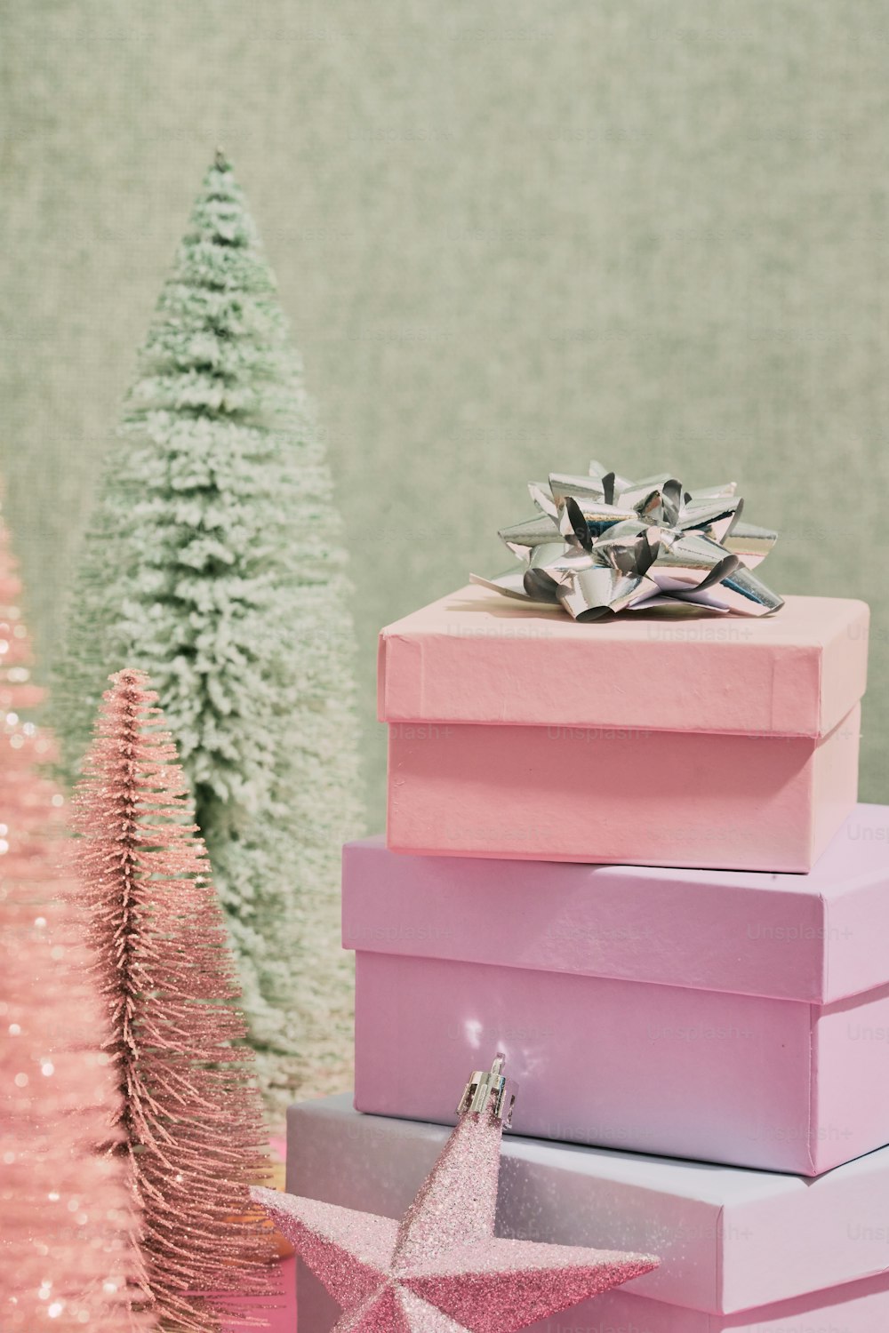 Una pila de cajas rosas junto a un árbol de Navidad