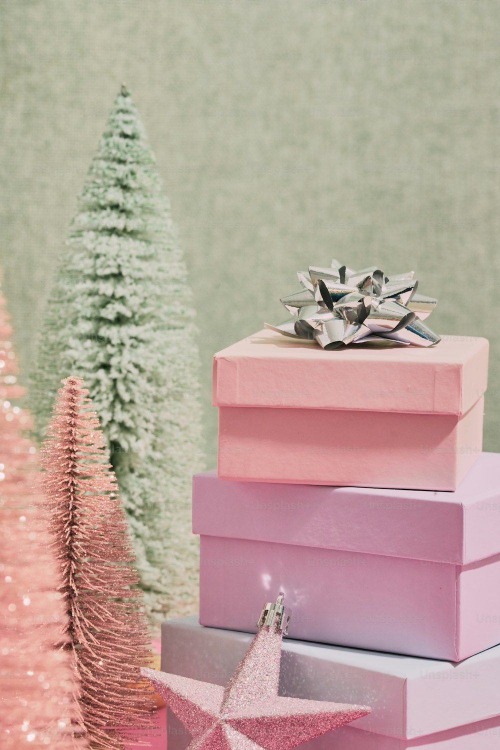 a stack of pink boxes sitting next to a christmas tree
