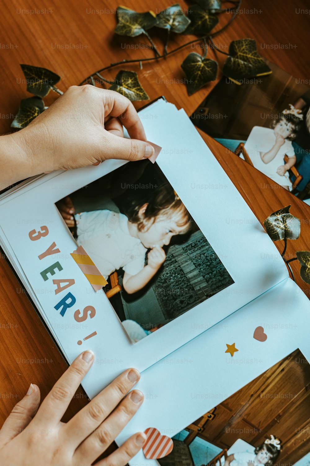 a person holding a picture of a child on a table