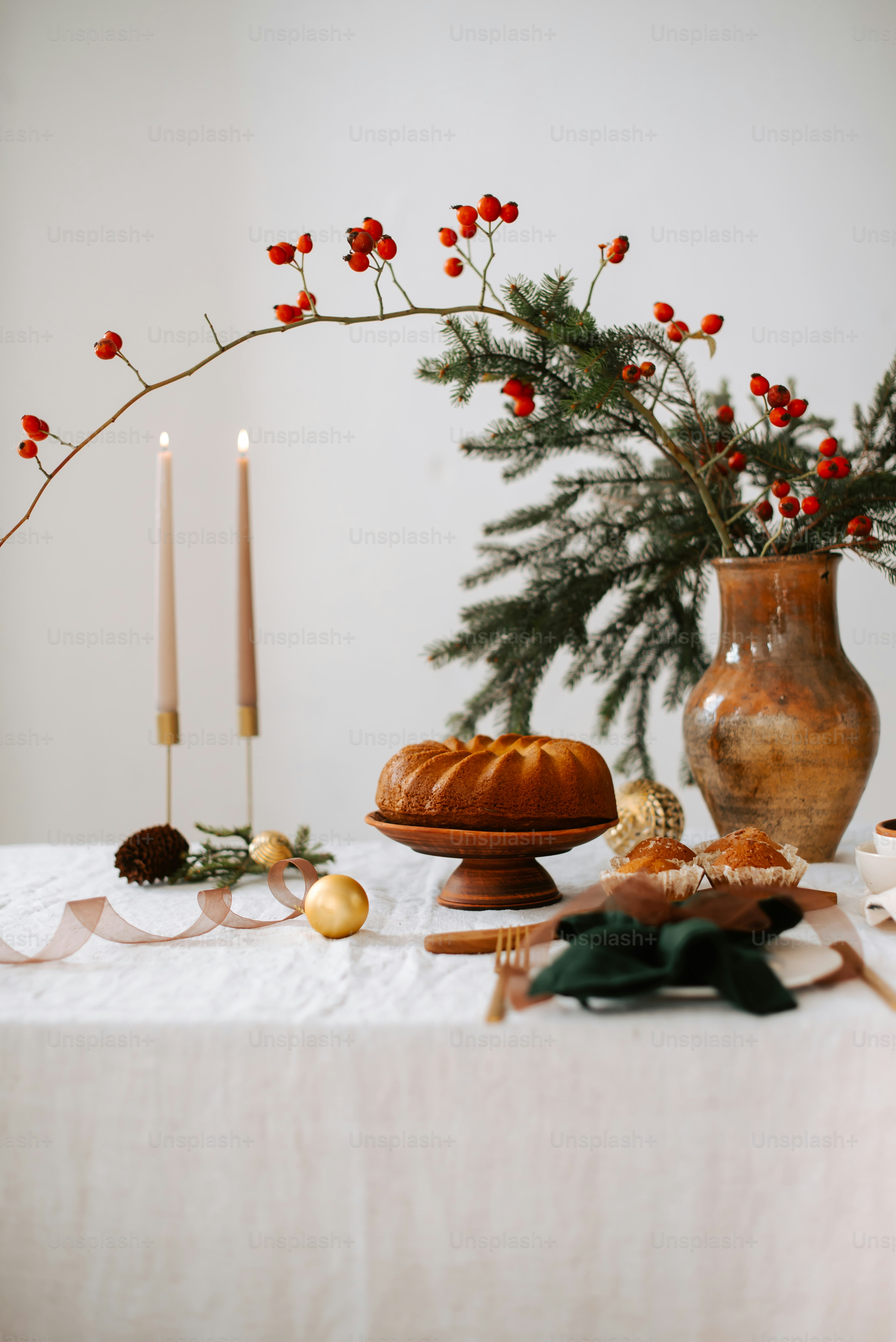 a table topped with a cake next to a vase filled with flowers