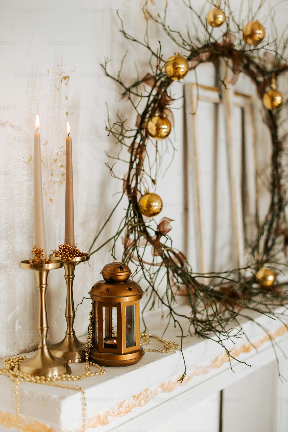 a candle and a wreath on a mantle