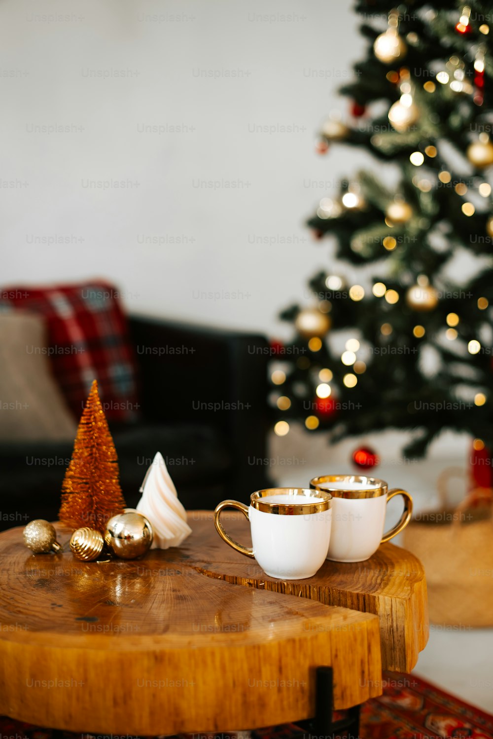 two cups on a table with a christmas tree in the background