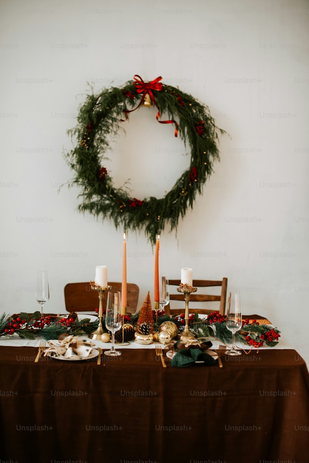 a table with a wreath and candles on it
