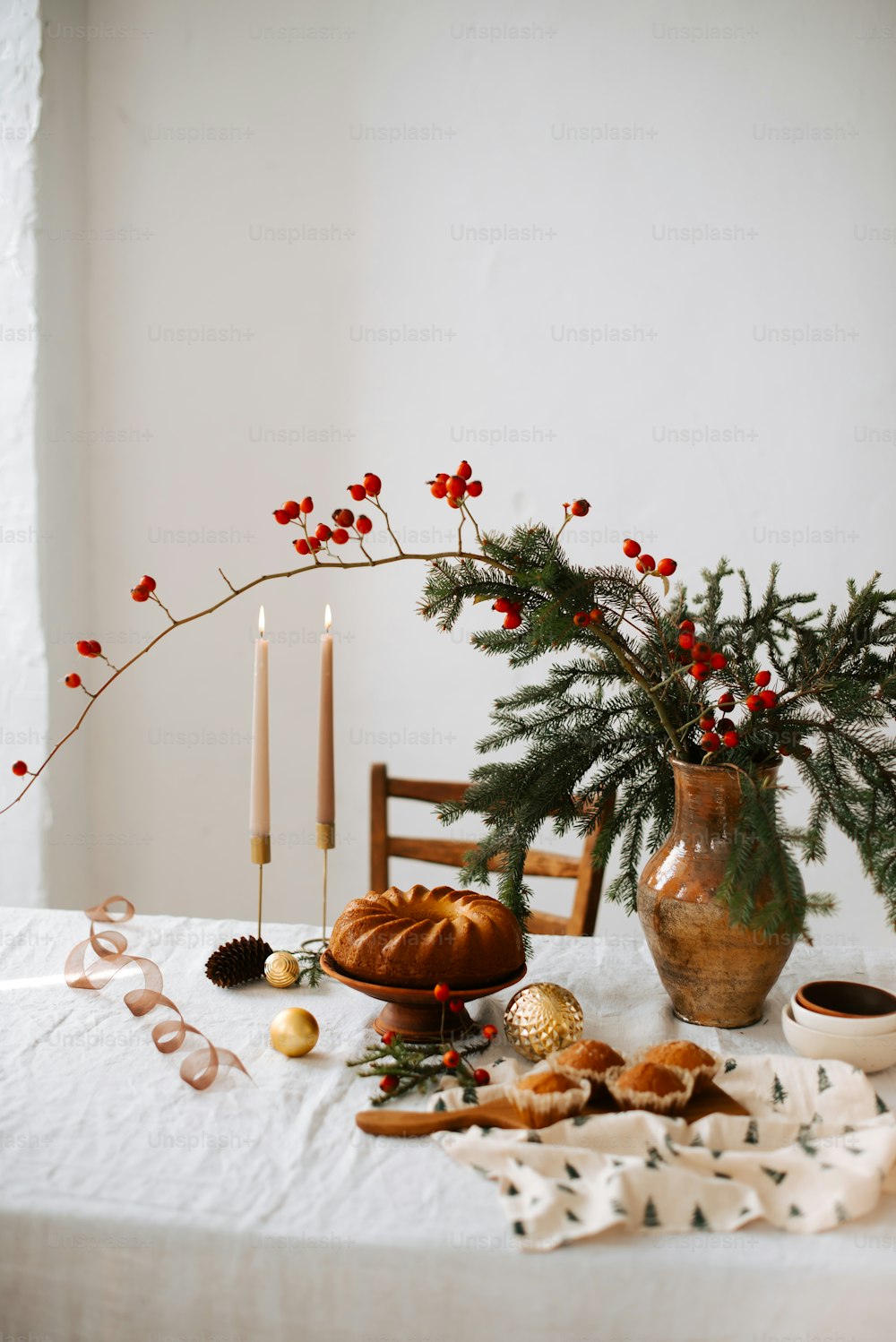 a table topped with a vase filled with christmas decorations