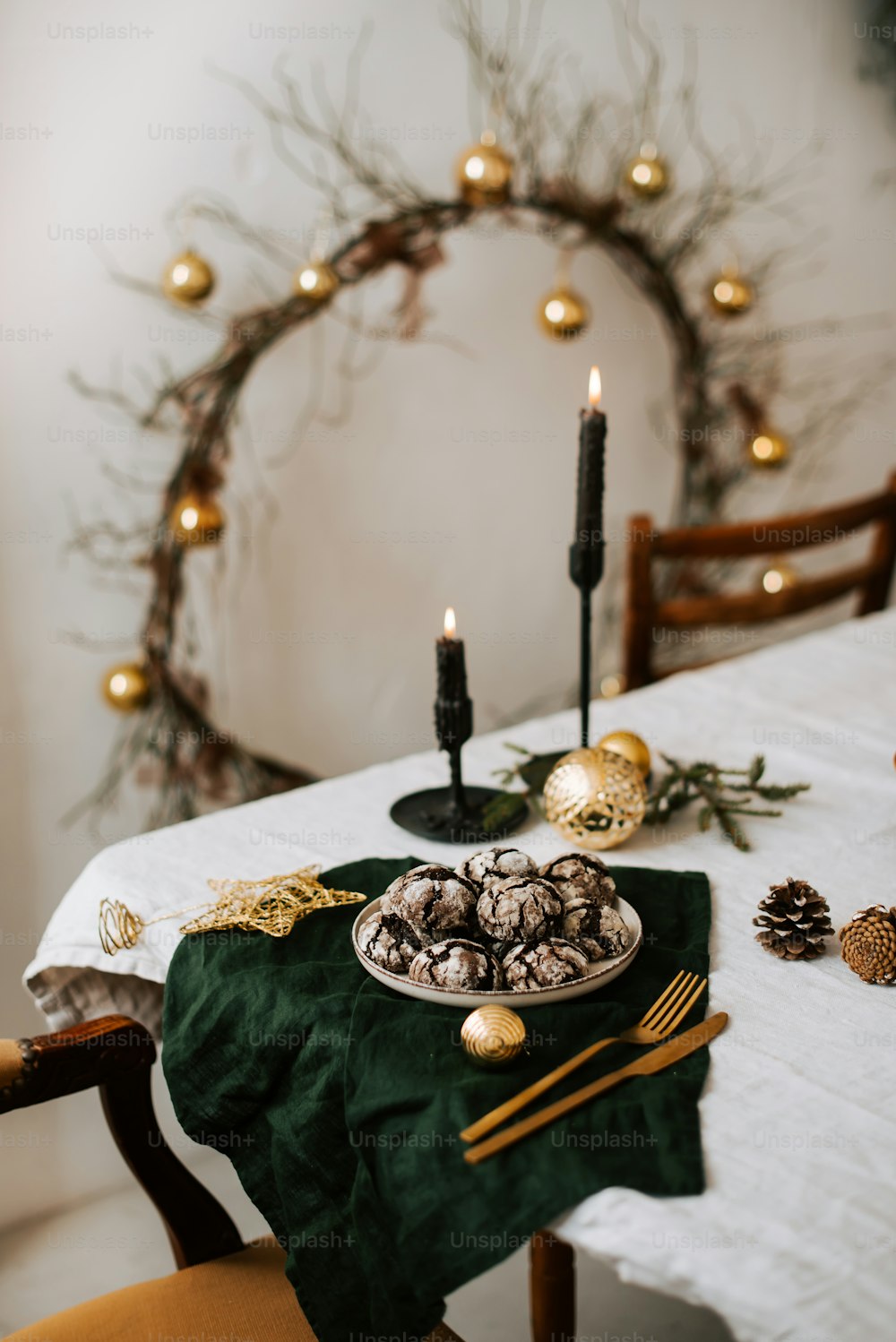 Ein Tisch mit einem Teller mit Essen neben einem Weihnachtskranz