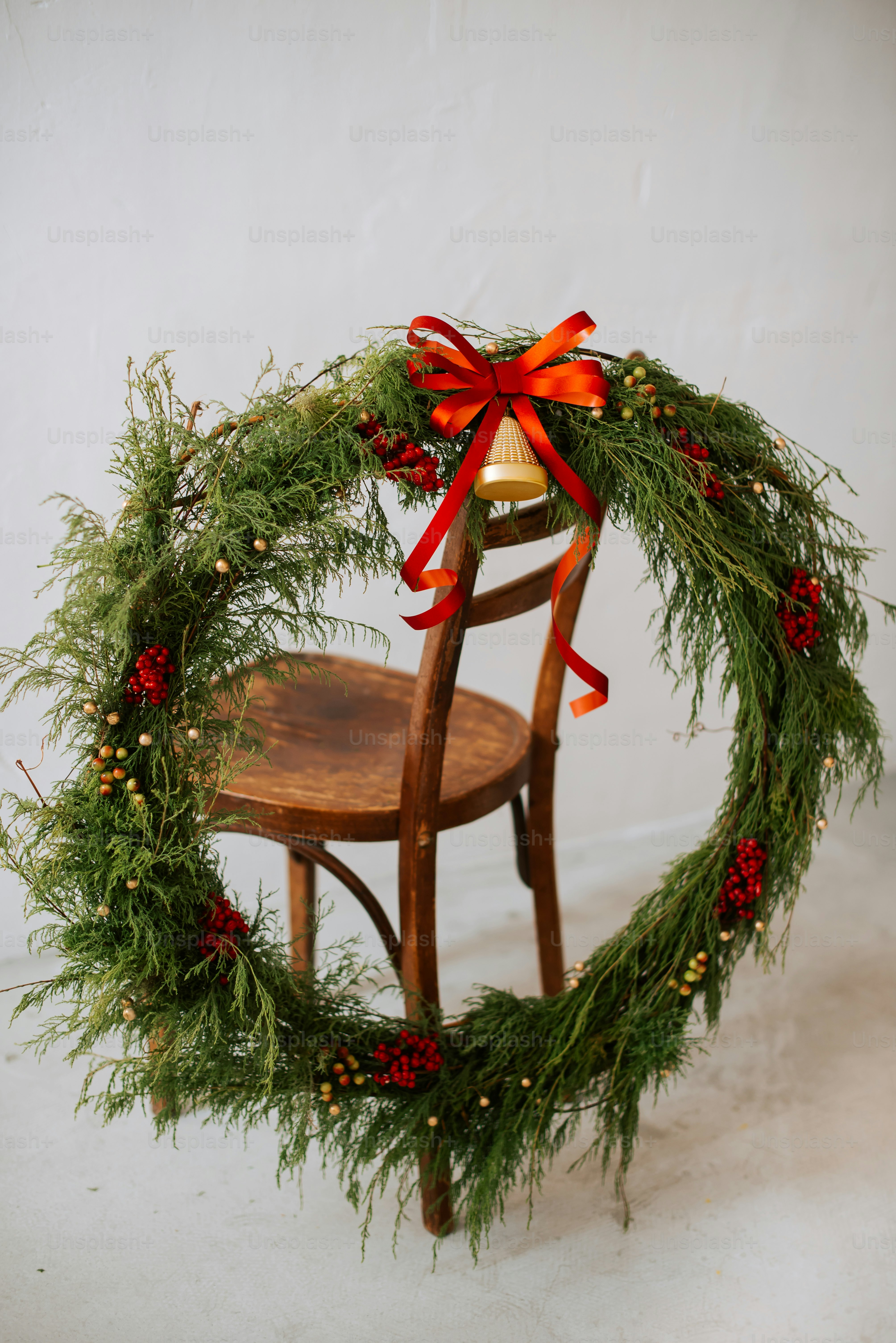 a wooden chair with a christmas wreath on top of it