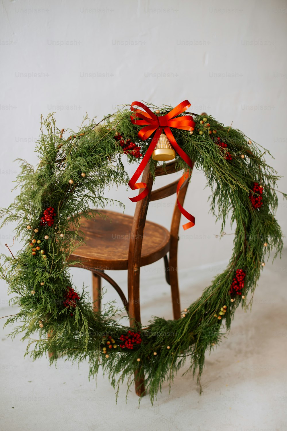 a wooden chair with a christmas wreath on top of it