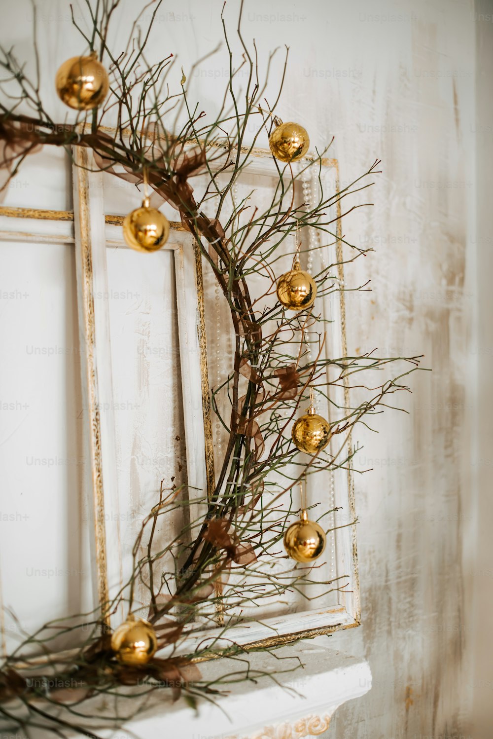 a wreath on a window sill with gold ornaments
