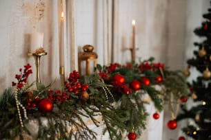 a christmas garland with red balls and greenery