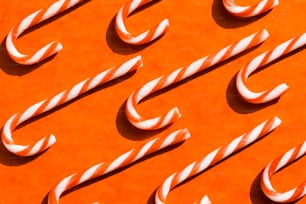 a group of candy canes sitting on top of an orange surface