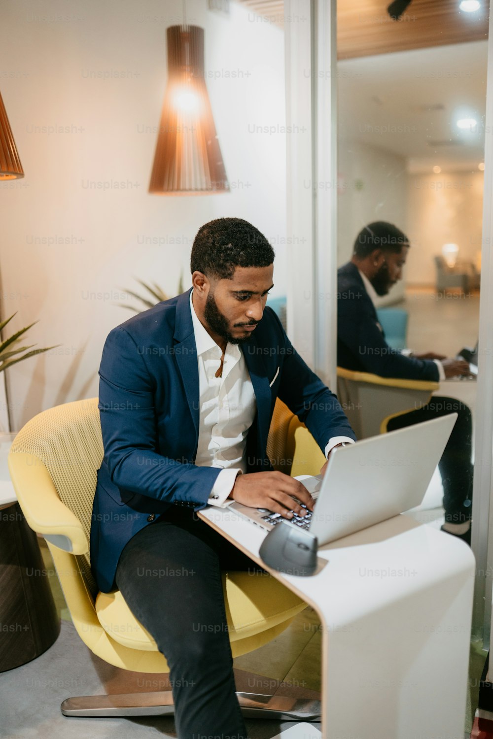 um homem sentado em uma mesa usando um computador portátil