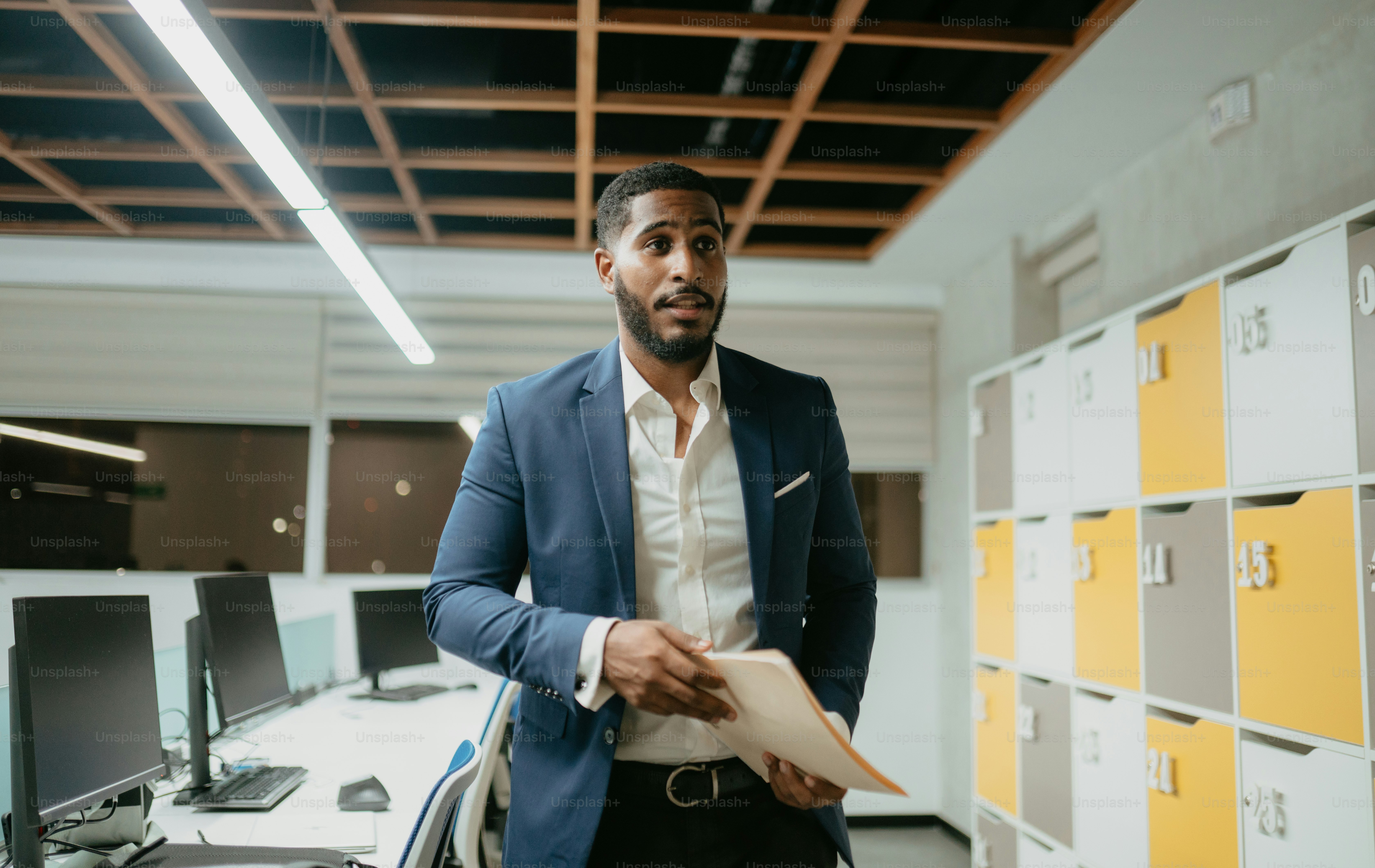 A man in a suit standing in front of a computer photo – Office Image on ...