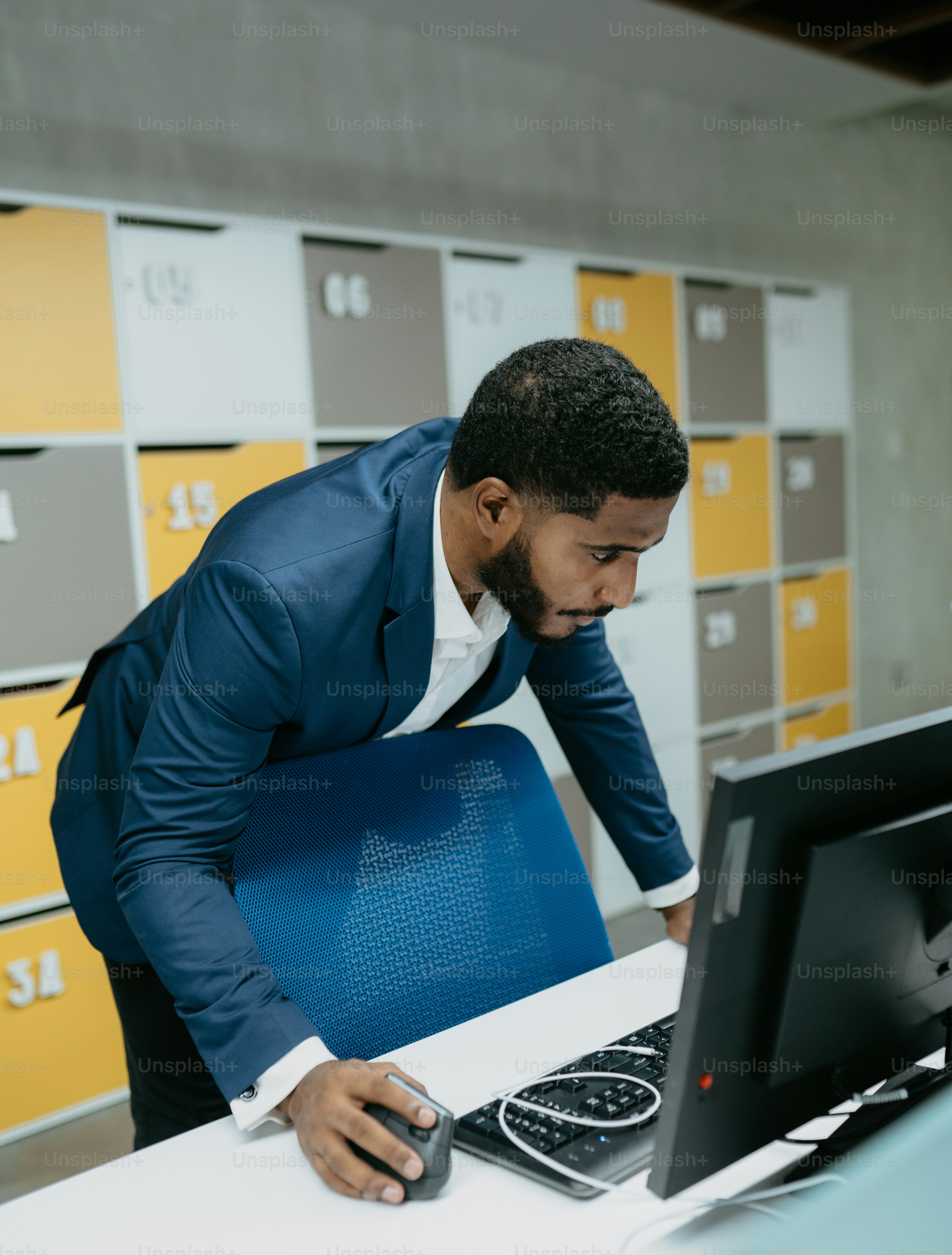 A man in a suit standing in front of a computer photo – Office Image on ...