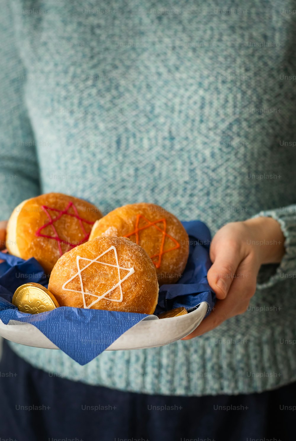 a person holding a basket of doughnuts with a star of david on it