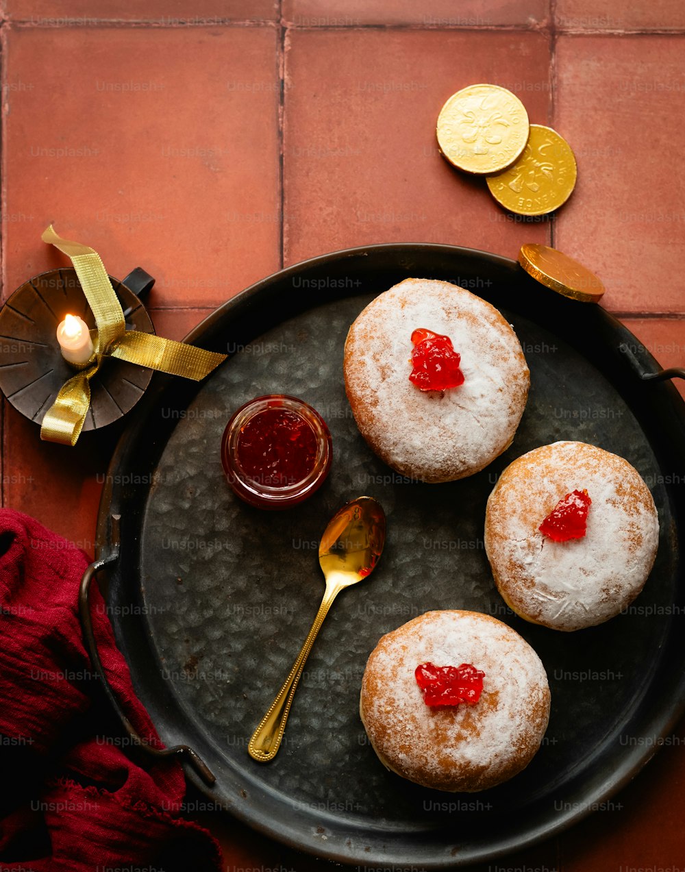 three powdered donuts with jelly on a plate