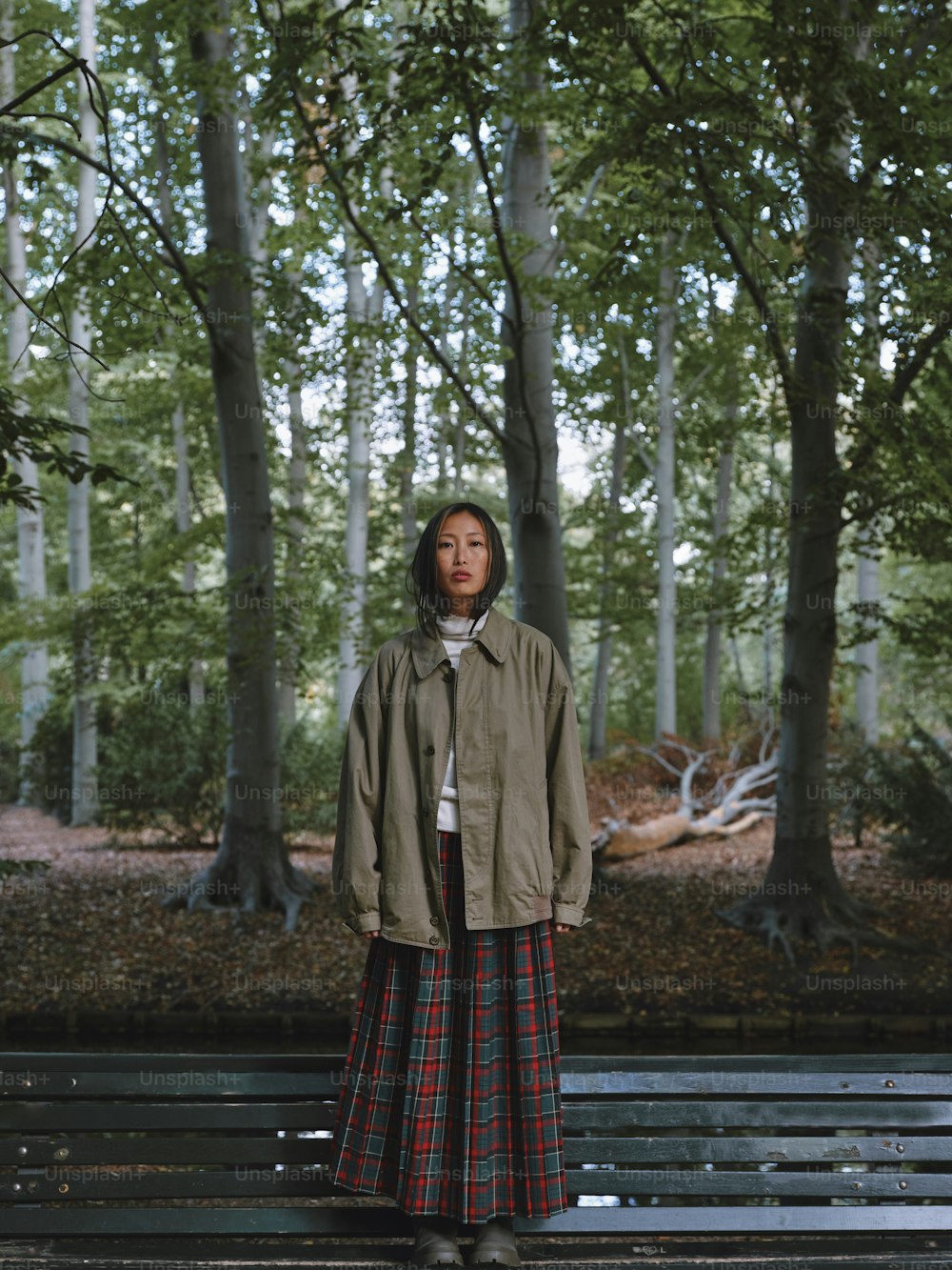 una mujer de pie en un banco en un bosque