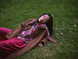a woman laying on the ground in the grass