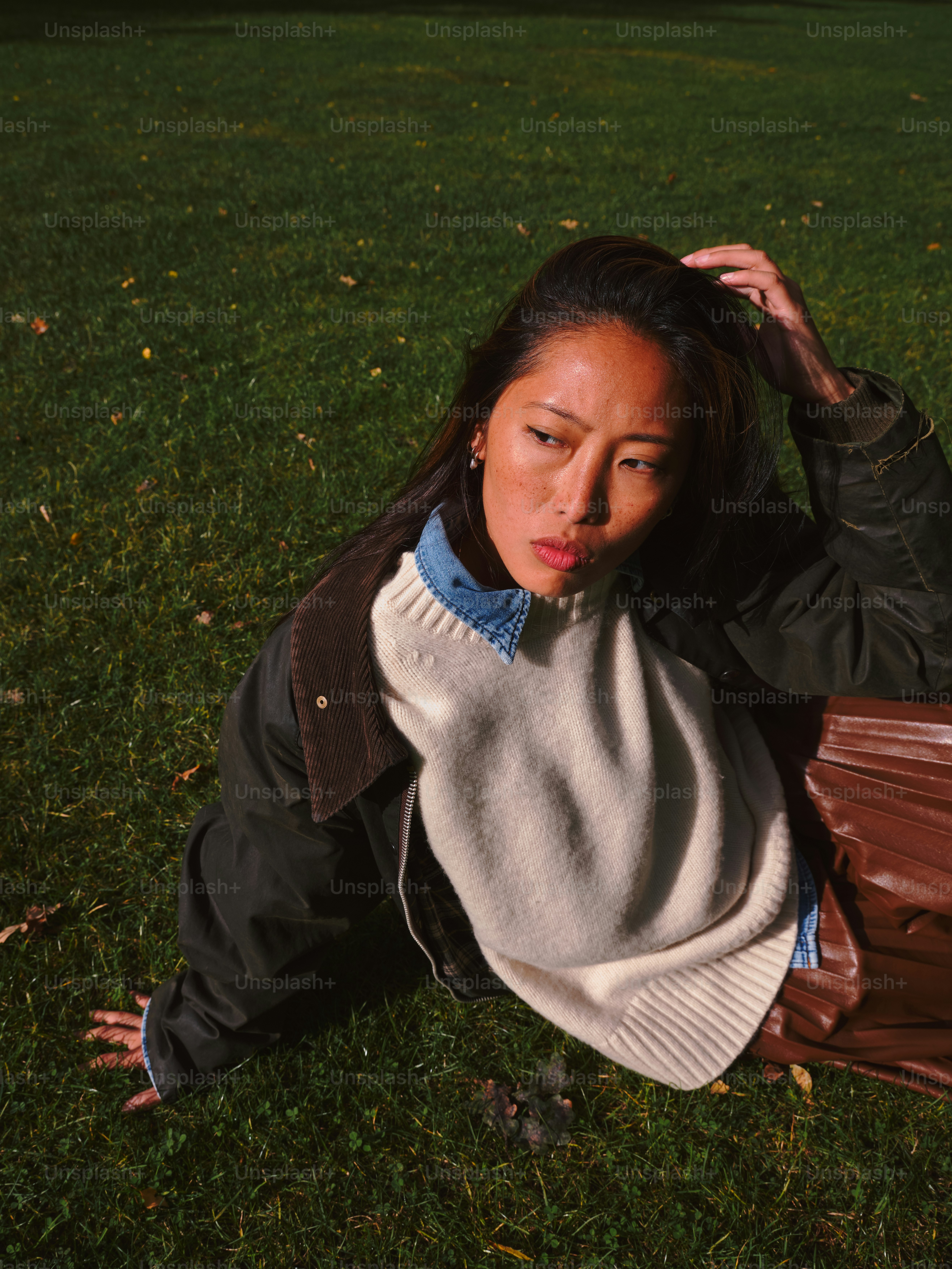 A woman laying on the ground with her hand on her head photo – Fall ...