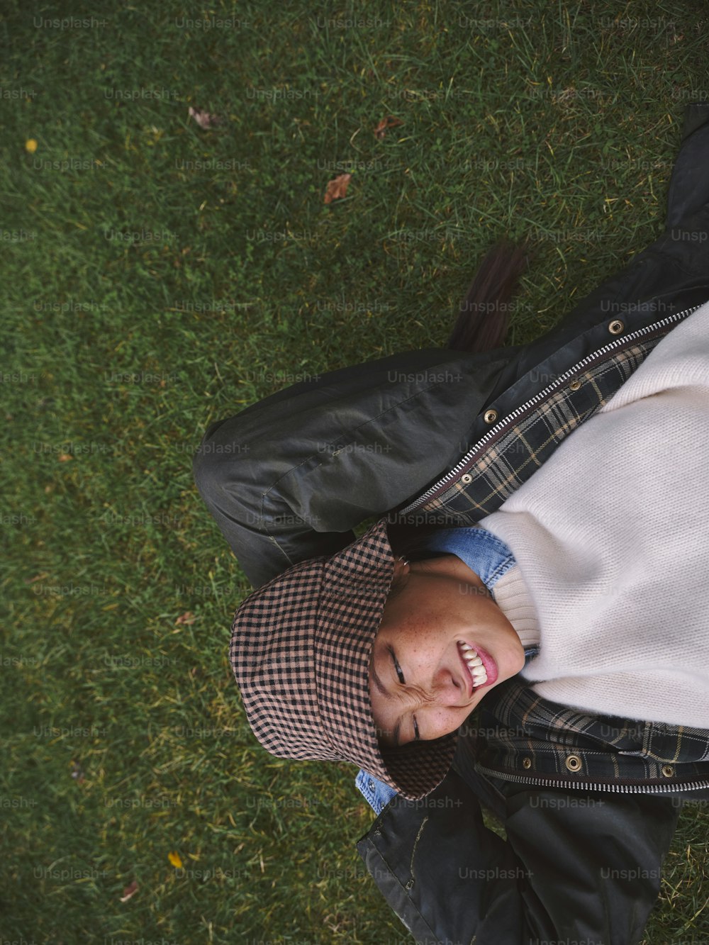 a man laying in the grass with a hat on
