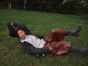 a woman laying on the ground in a park