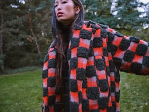 Une femme vêtue d’un manteau à carreaux rouge et noir
