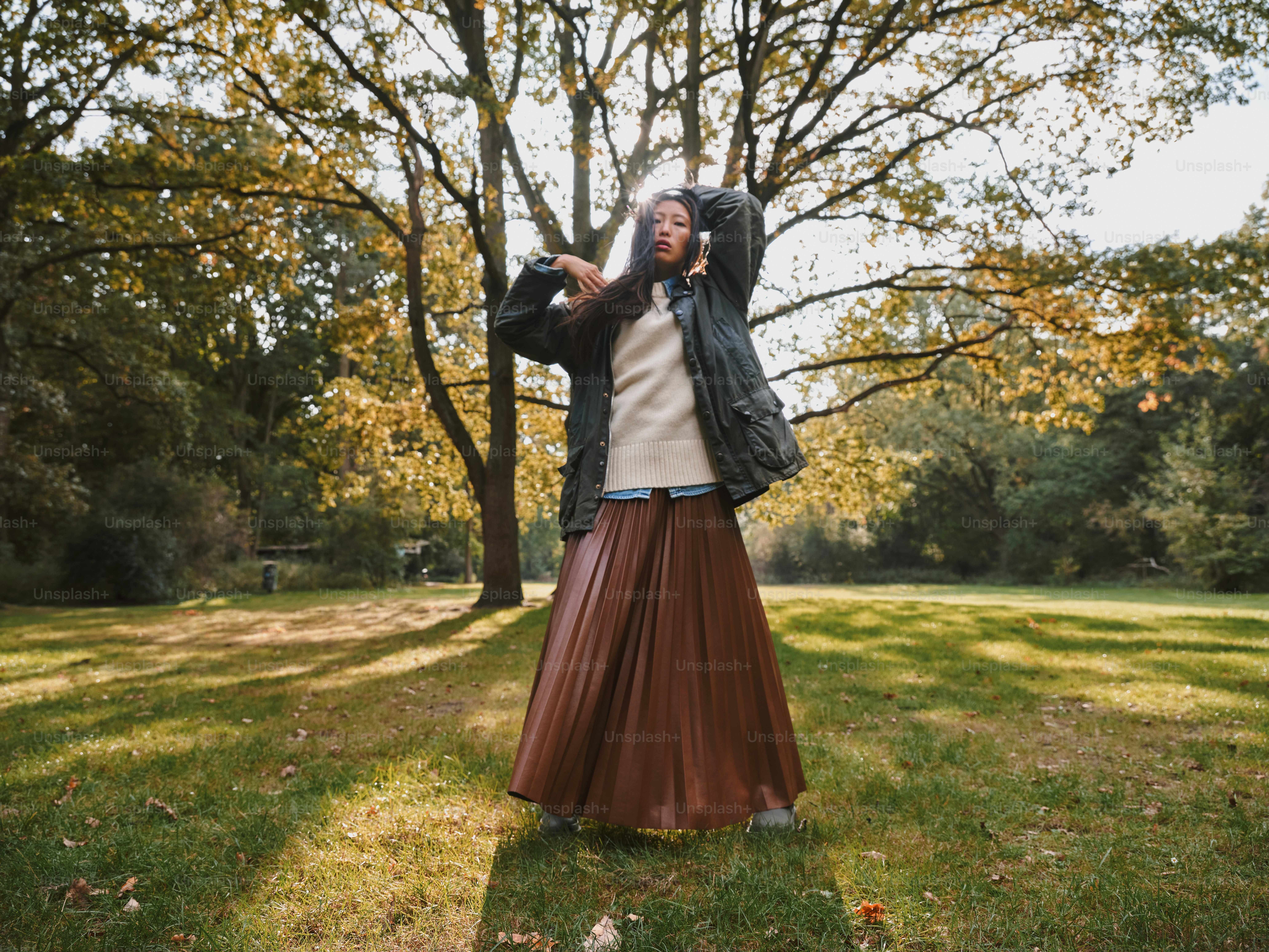 野原に手を伸ばして立っている女性