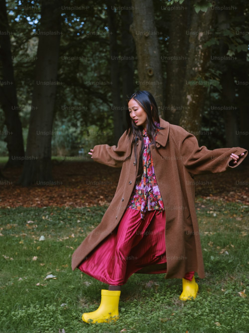 a woman in a brown coat and yellow rubber boots