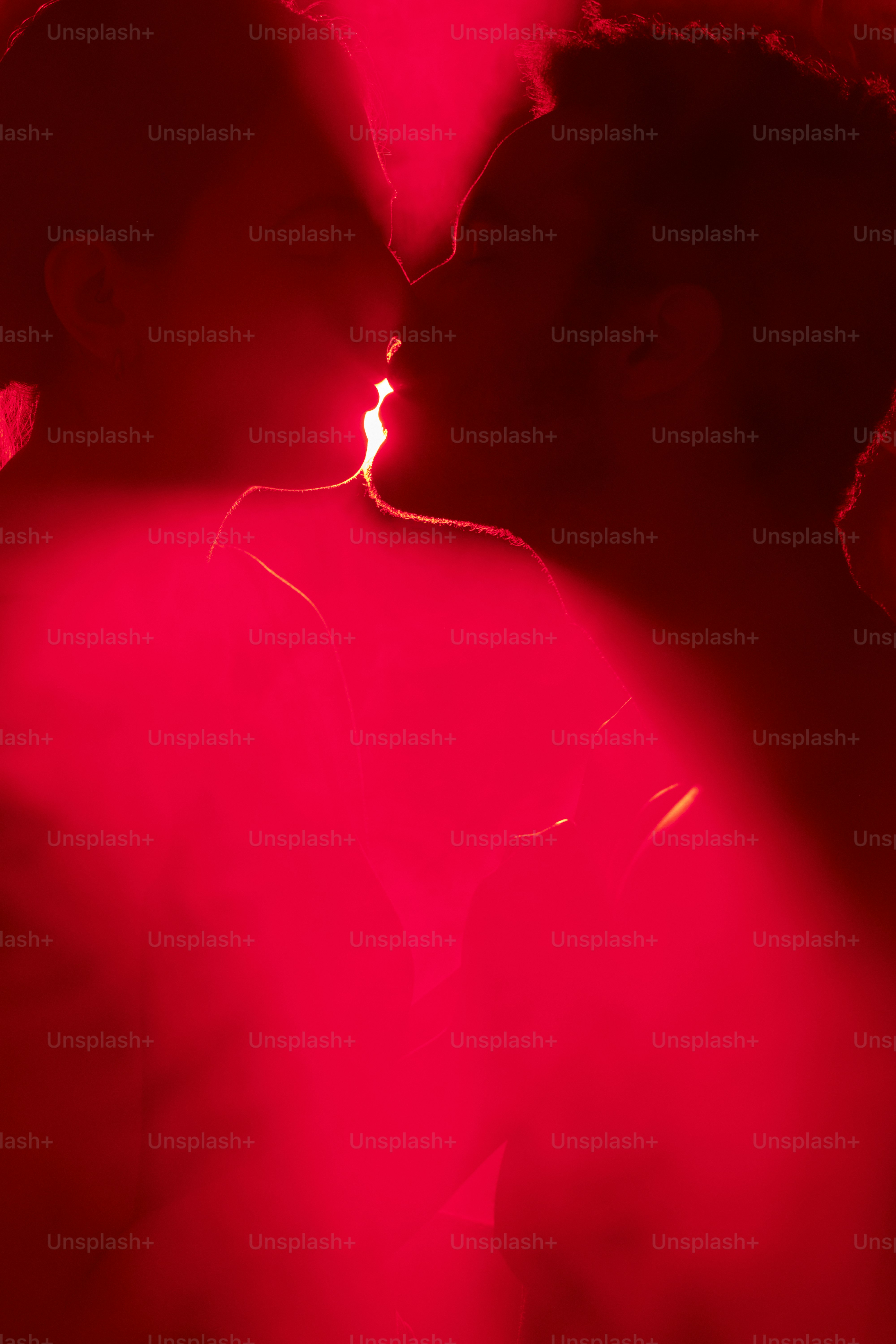 a man and a woman kissing in a red light