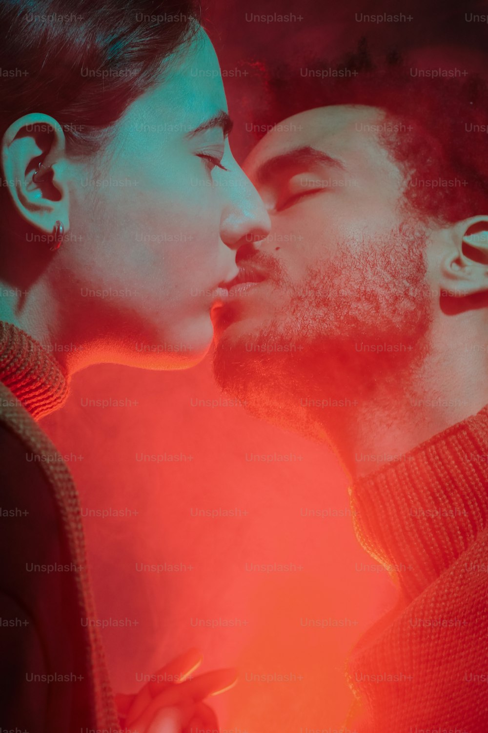 Ein Mann und eine Frau küssen sich vor einer roten Ampel