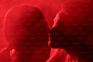 a man and a woman kissing in a red light