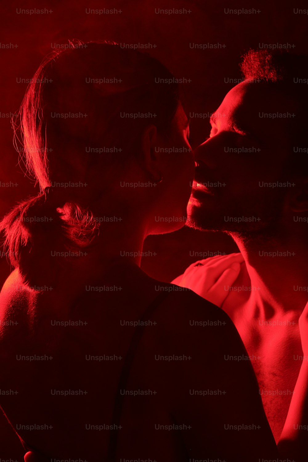 Un uomo e una donna si baciano nel buio