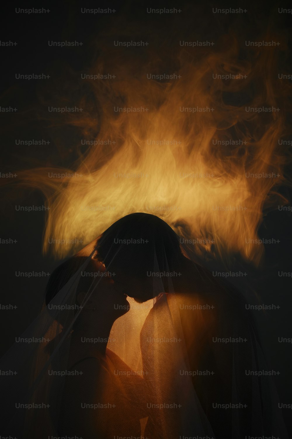 a man and a woman kissing in front of a fire