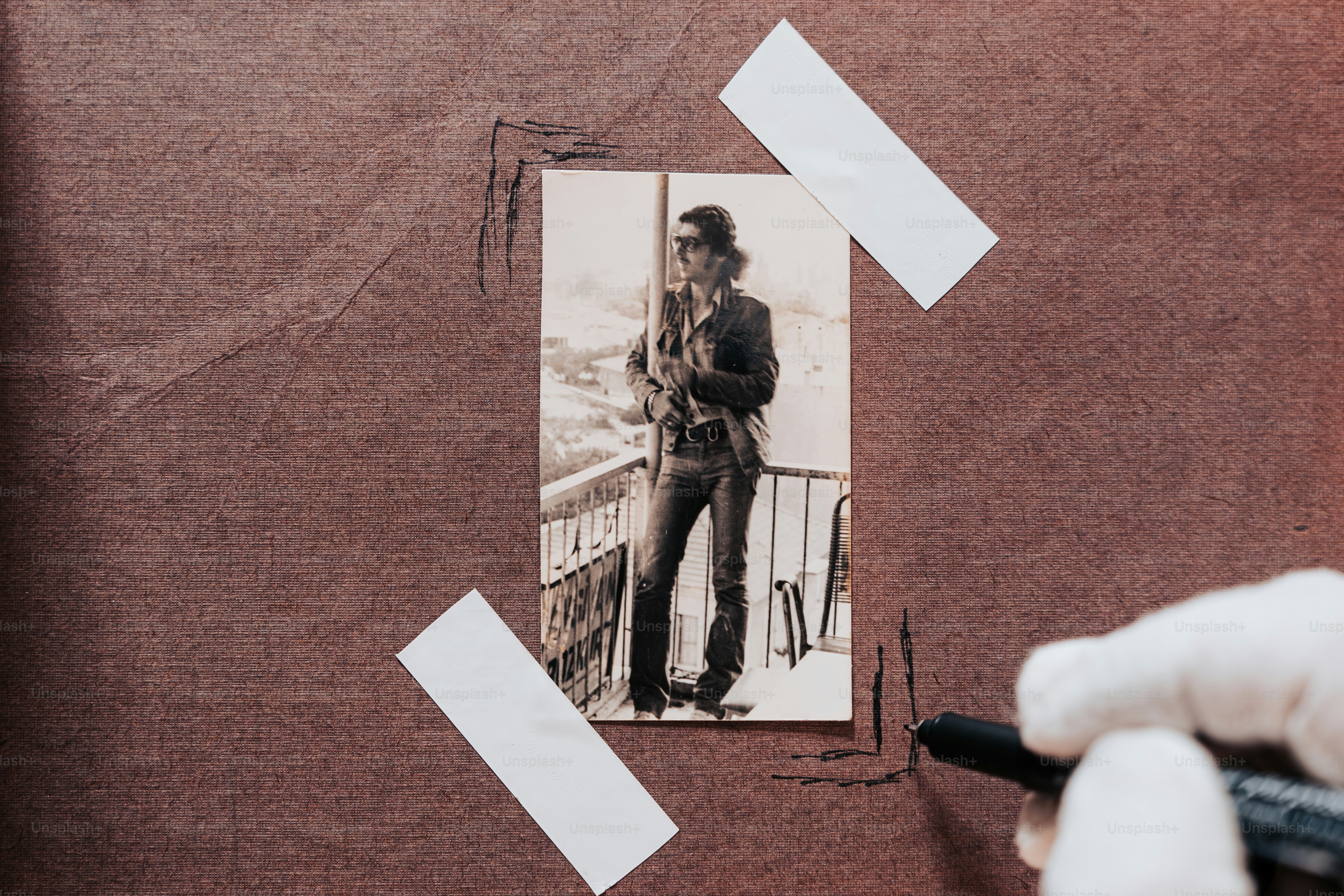 a person holding a pen near a picture of a man