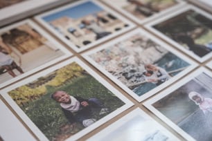 Un montón de fotos Polaroid están dispuestas sobre una mesa