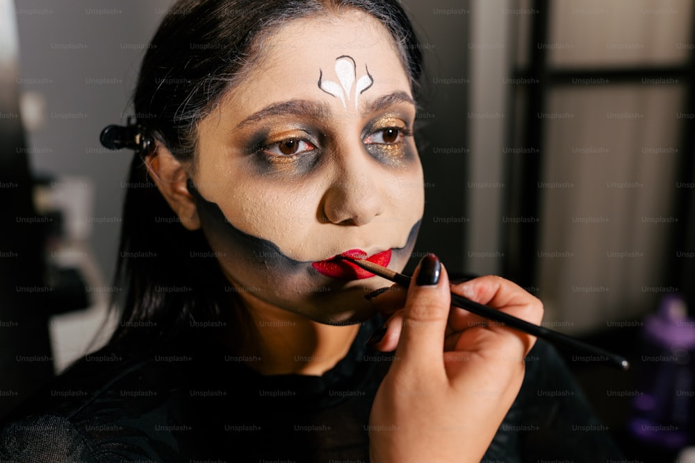 a woman with face paint is doing makeup