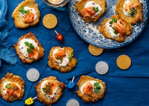 a blue plate topped with crab cakes next to a cup of tea