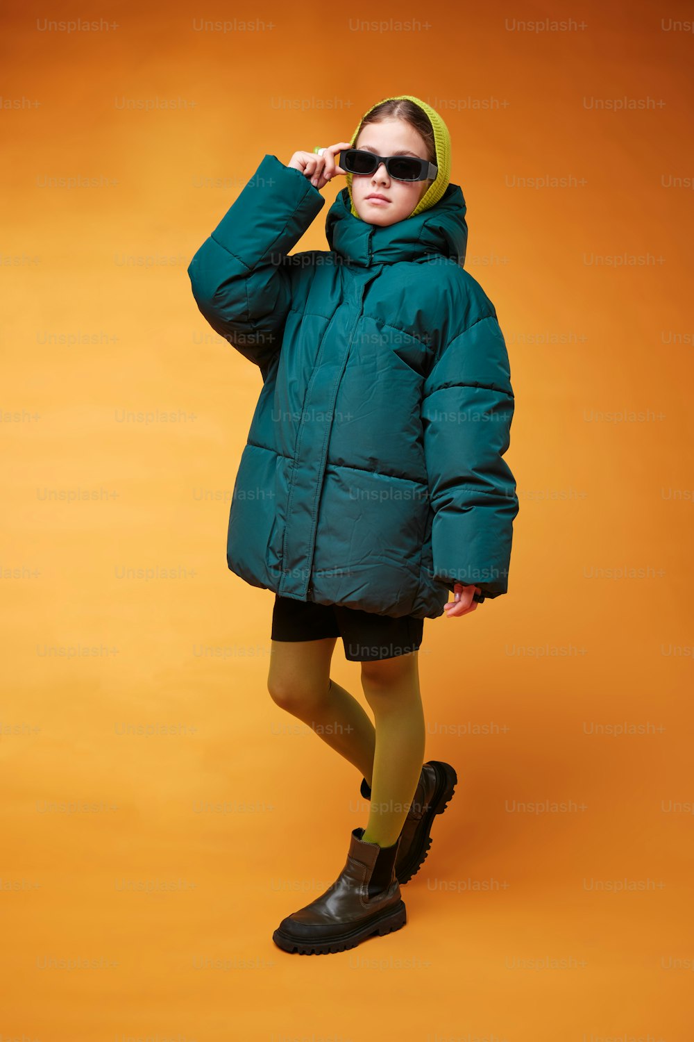 a woman in a green coat and black boots