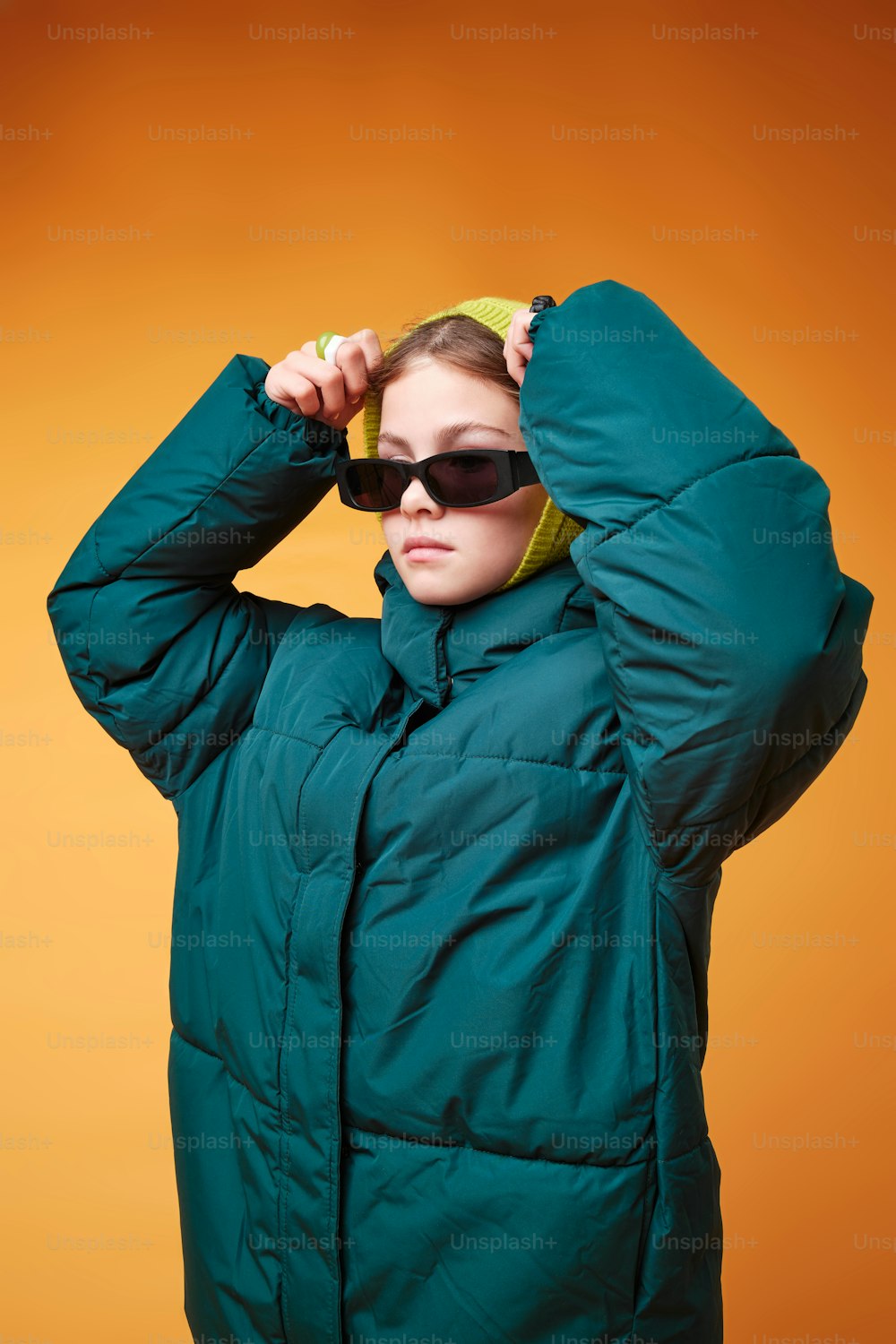 a woman in a green jacket and sunglasses