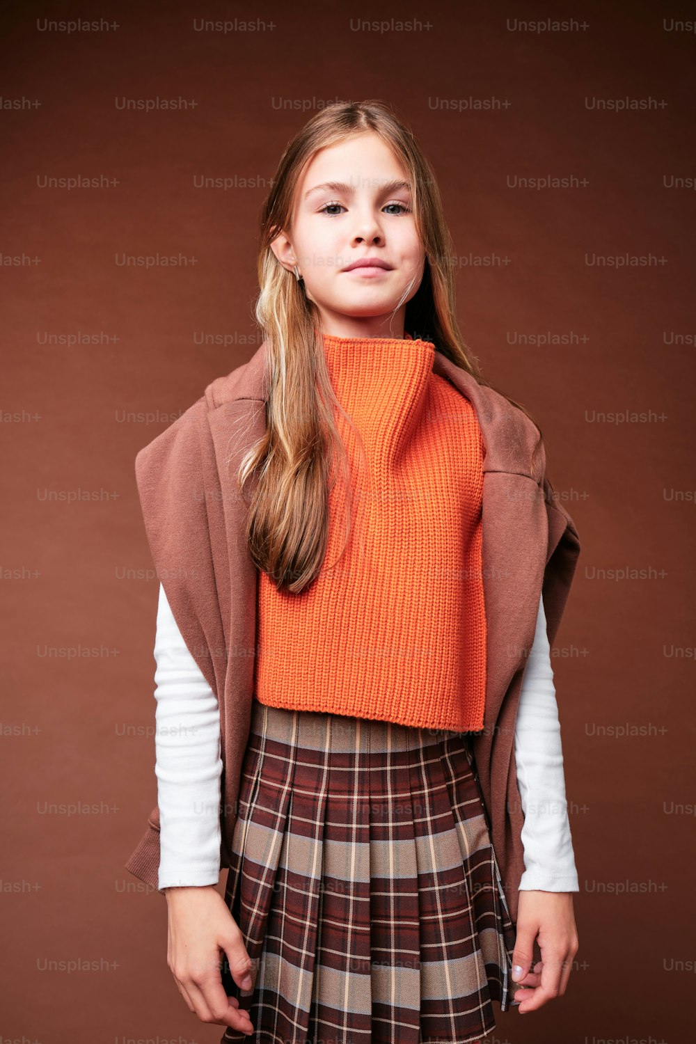 a young girl wearing a skirt and a sweater
