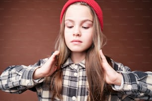 a young girl wearing a red hat and a plaid shirt