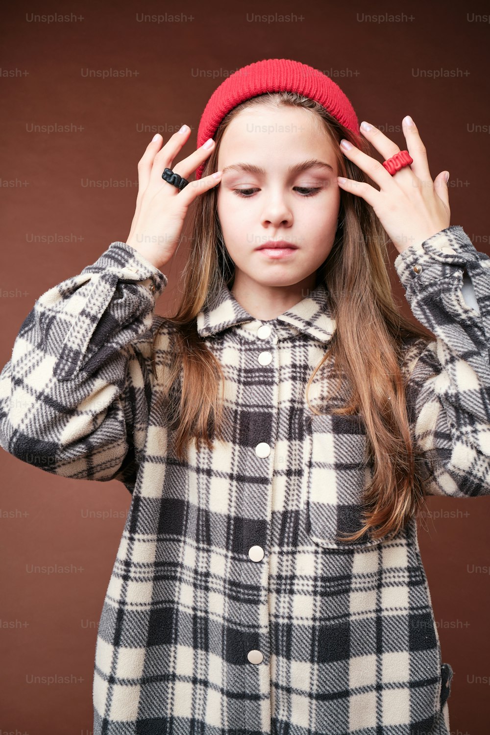 a young girl is holding her head with both hands