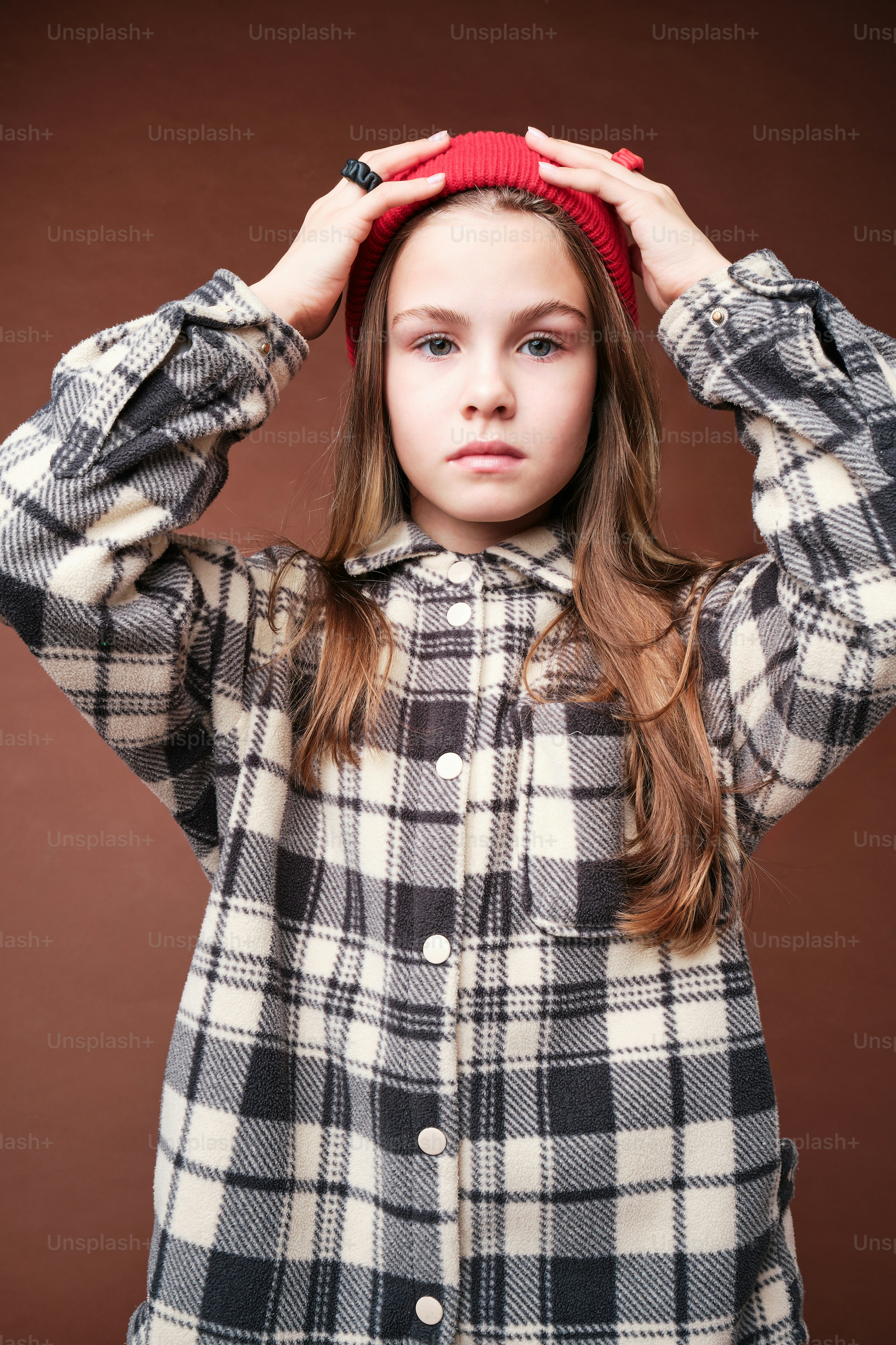 A girl in autumn clothes on studio background in warm color scheme