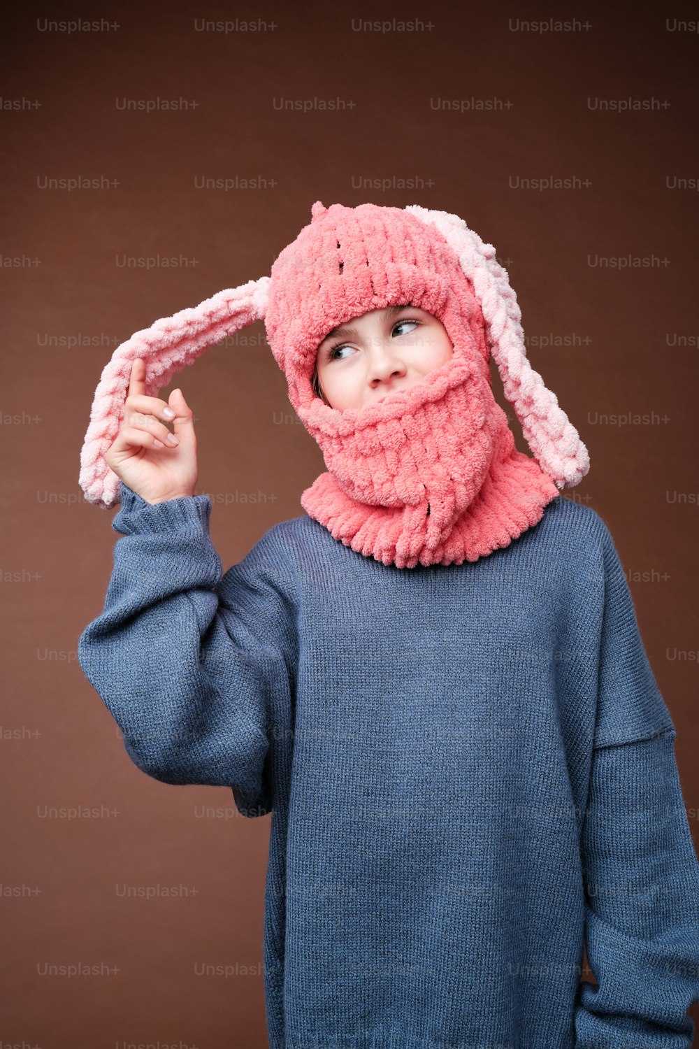 a little girl wearing a pink hat and scarf
