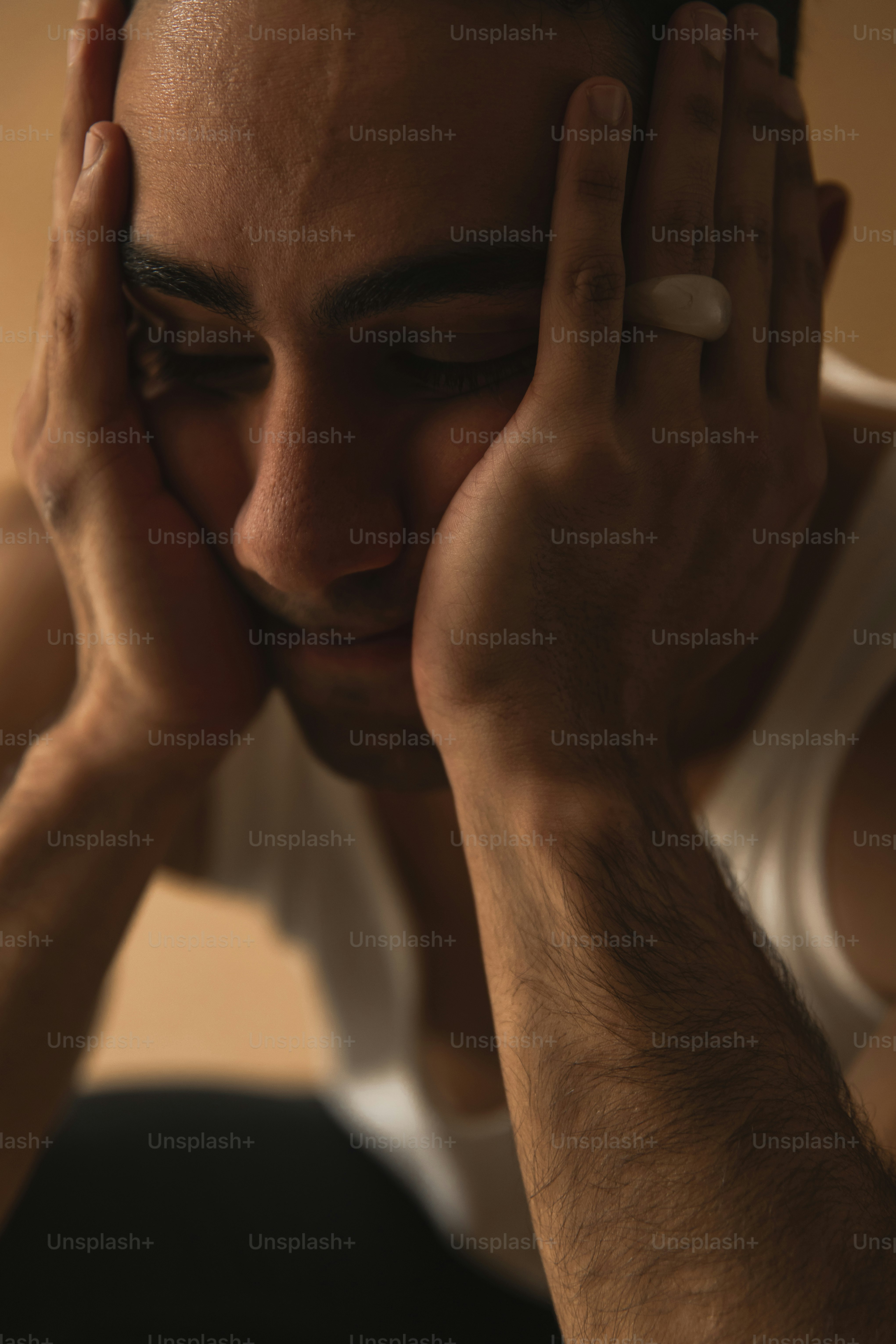 a man holding his hands to his face