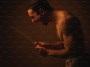 a shirtless man holding a knife in his hands