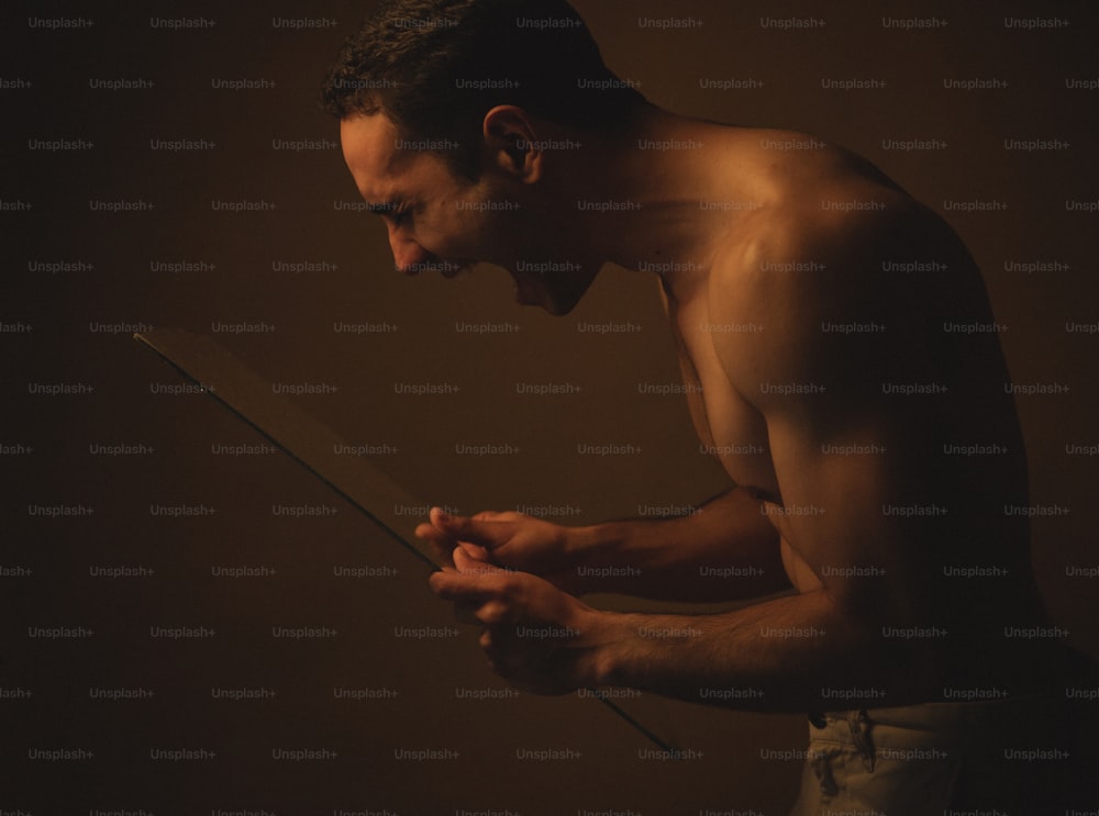 a shirtless man holding a knife in his hands