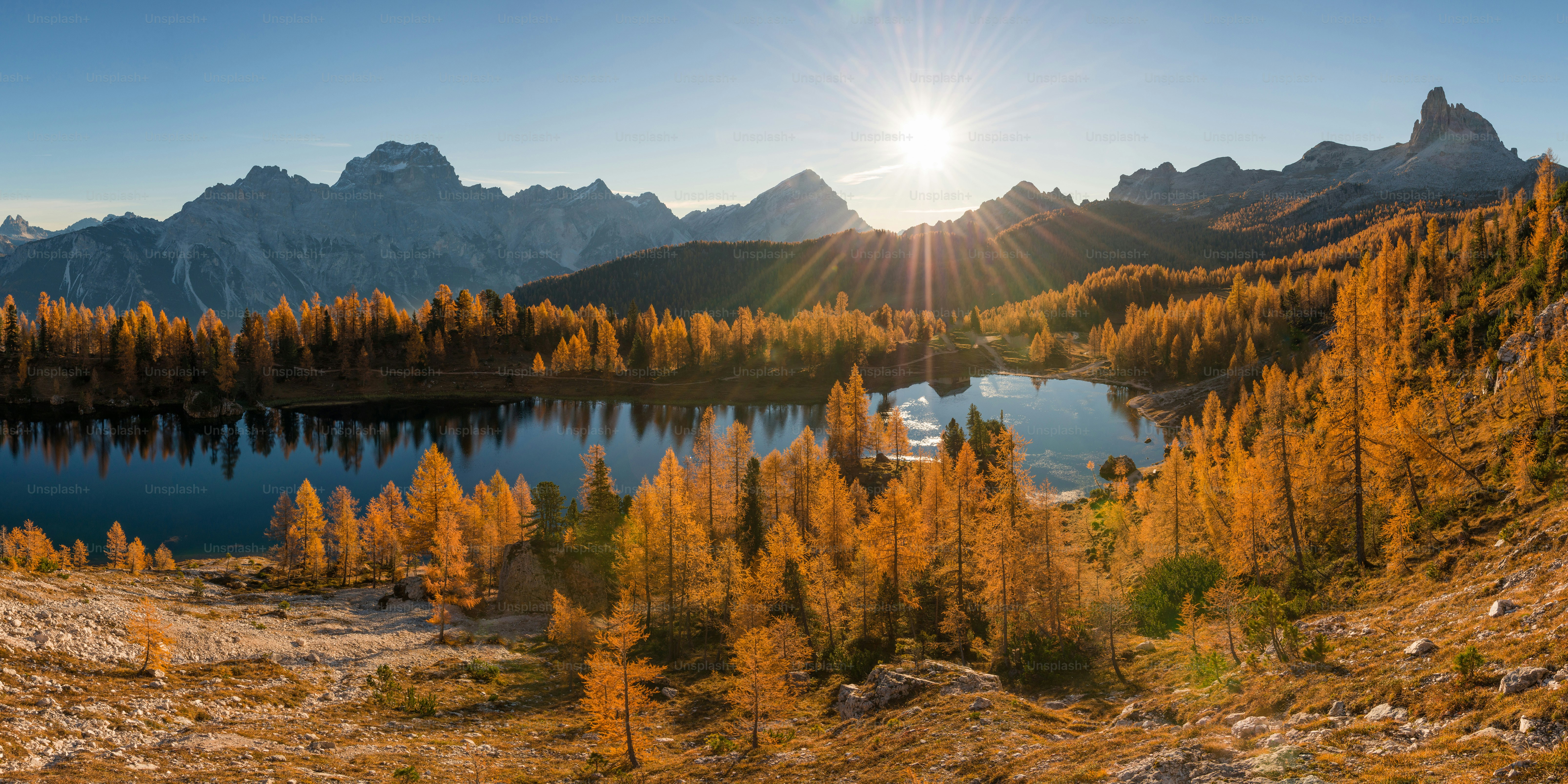 The sun is shining over a mountain lake photo – Land Image on Unsplash