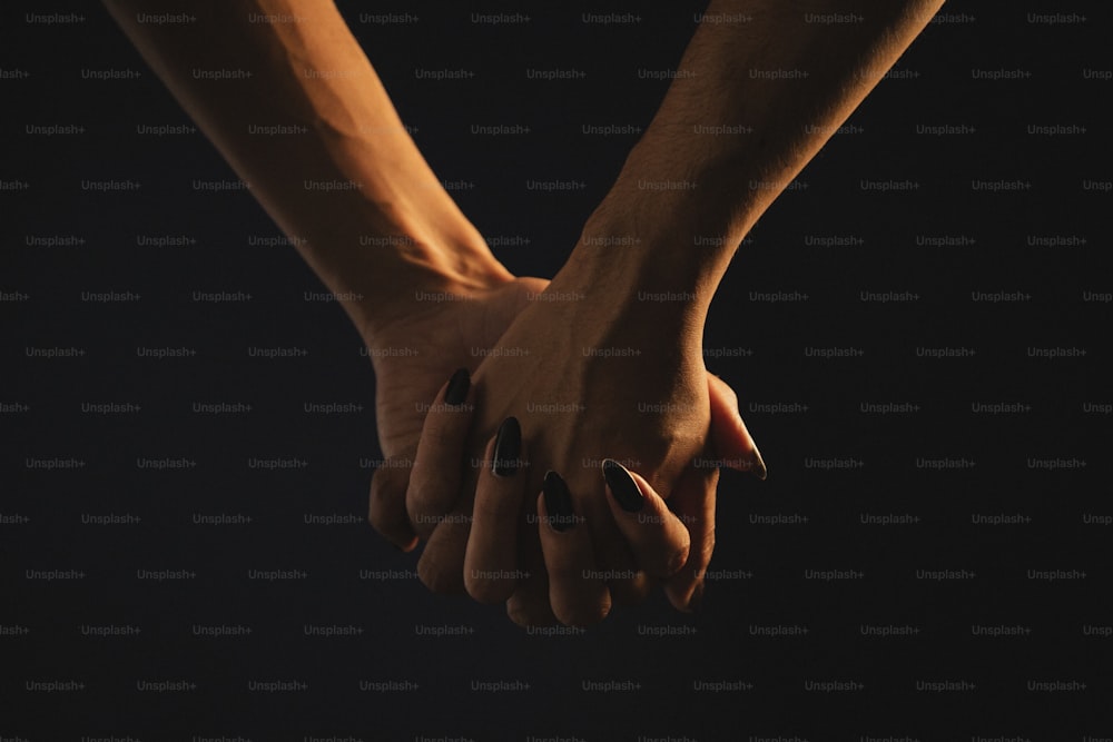 two people holding hands in the dark