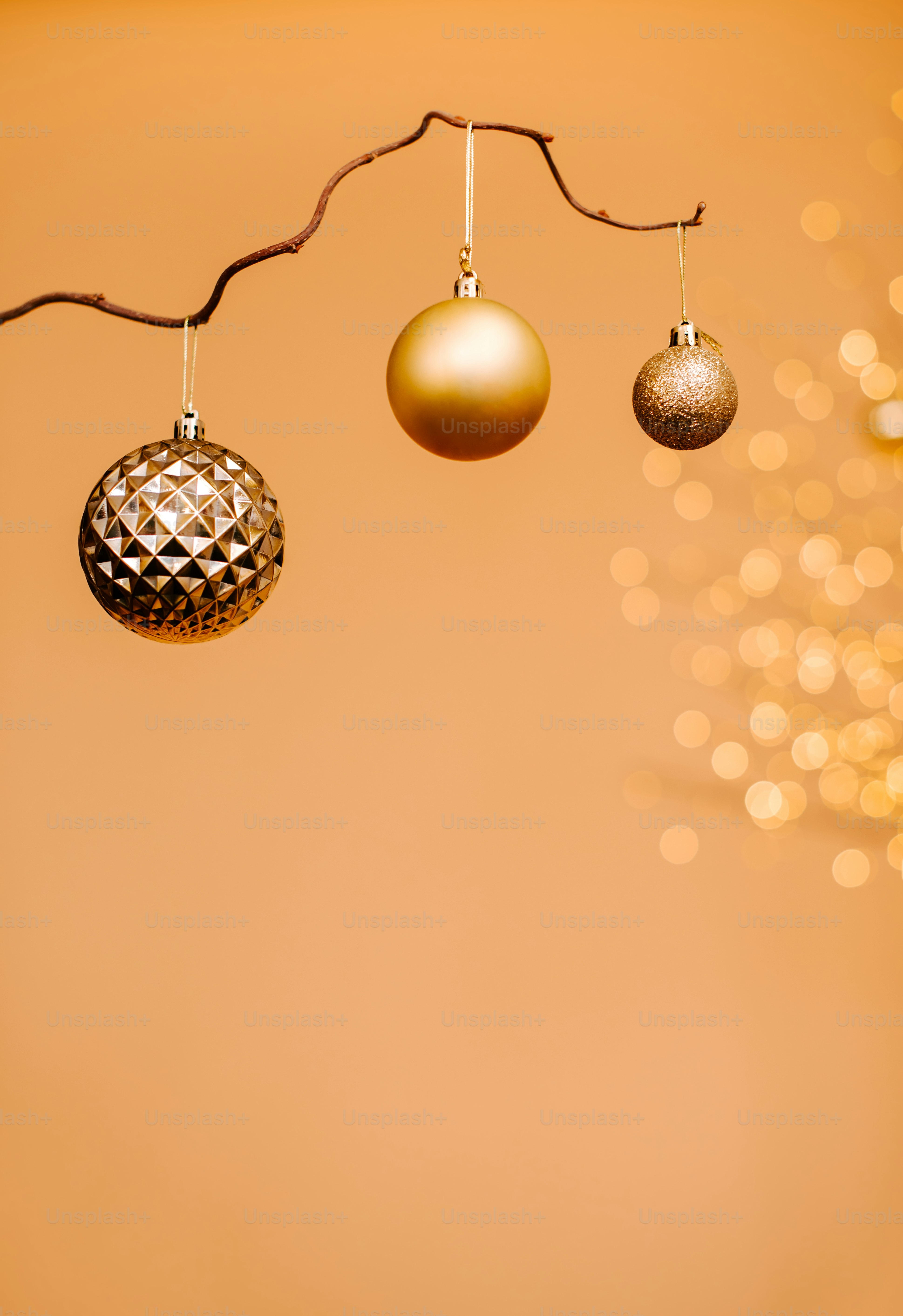 three christmas ornaments hanging from a tree branch